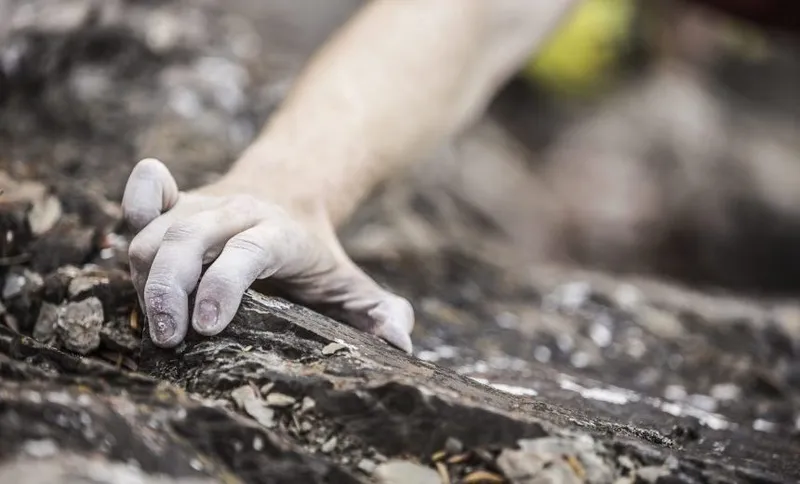 Hand of Caucasian man rock climbing