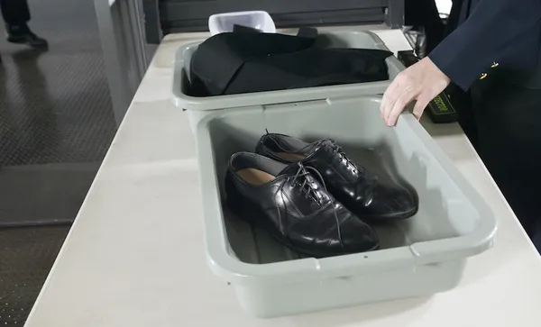 Shoes and Clothes in Containers on a table at Airport Customs