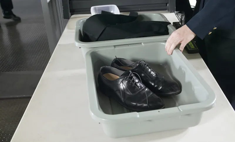 Shoes and Clothes in Containers on a table at Airport Customs
