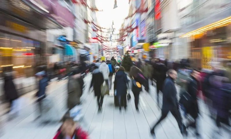 Blurred motion of crowd walking on city street during rush hour