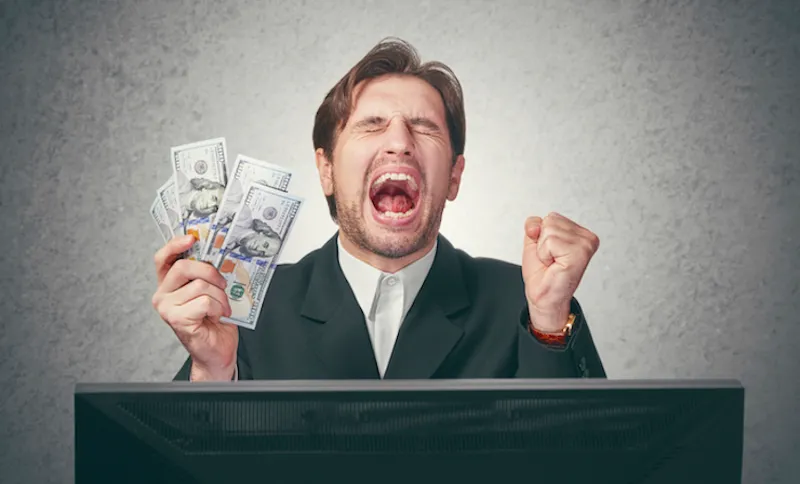happy businessman with money in hand  and computer