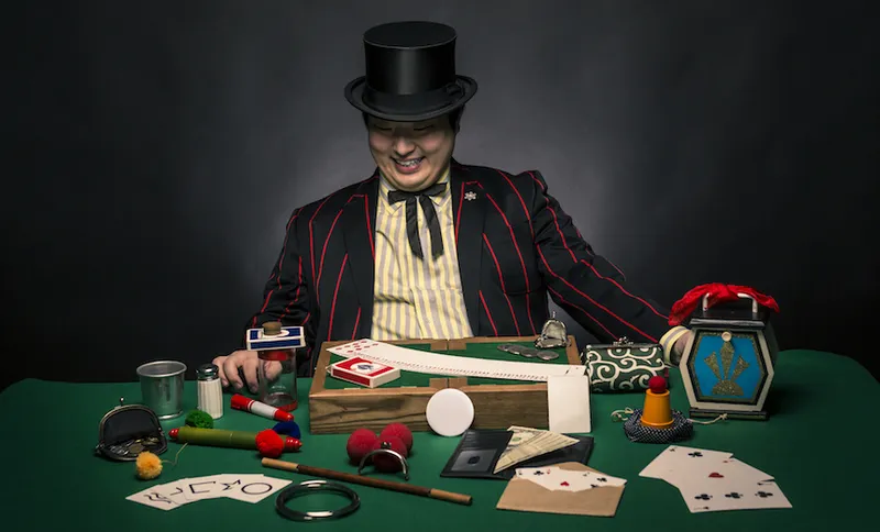 A magician sitting with his tricks
