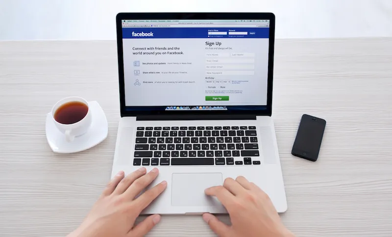 man sitting at the MacBook retina with site Facebook on the screen