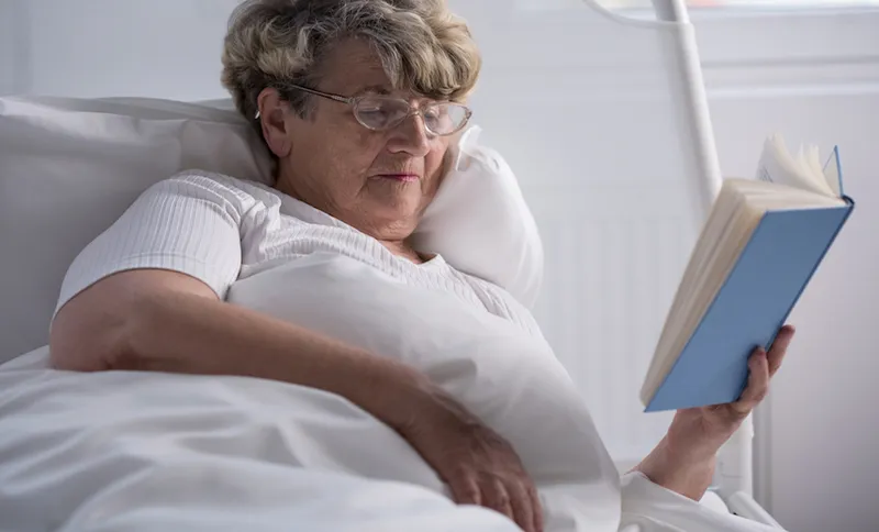 Woman reading book in bed
