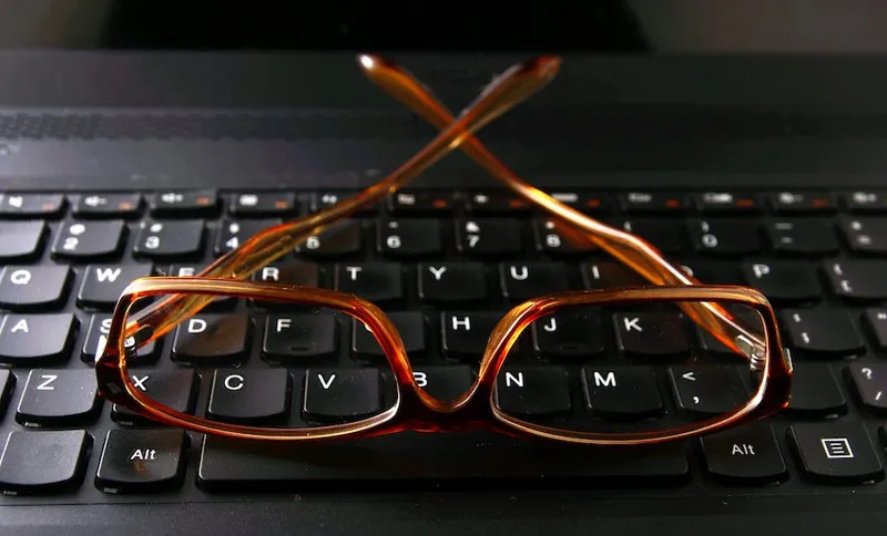 Pair of eyeglasses on a computer keyboard