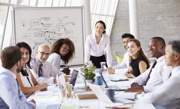 Asian Businesswoman Leading Meeting At Boardroom Table