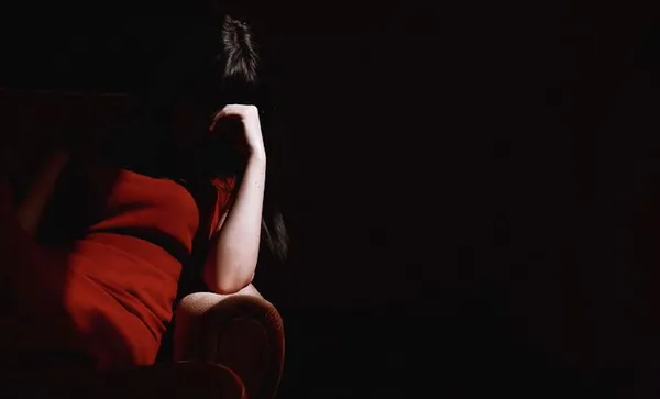 Woman Sitting On Sofa With Head In His Hand