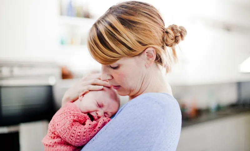 Mother holding newborn daughter