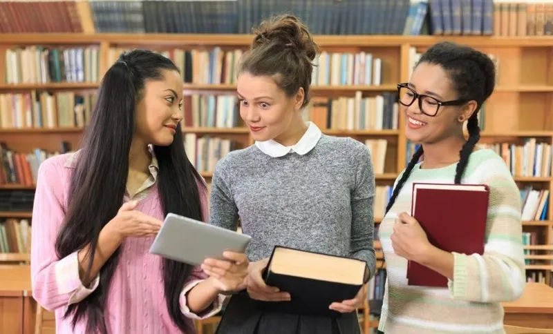 Three classmates having fun at library