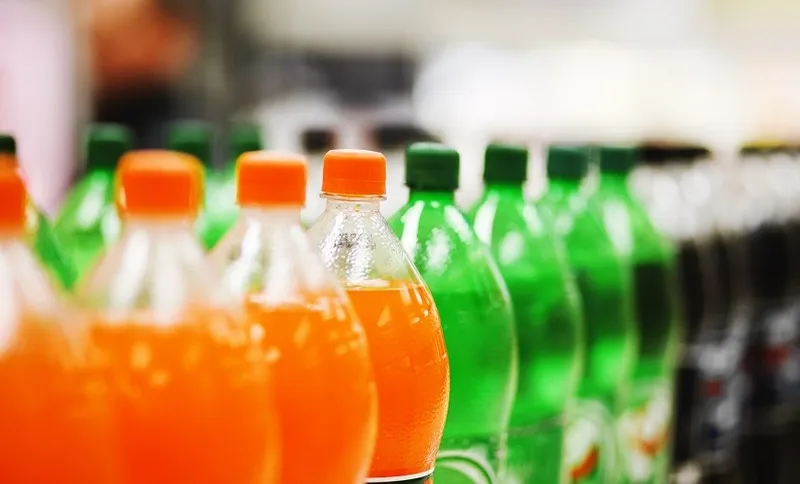 Lots of soda bottles in various flavours all lined up