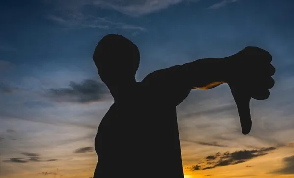 Silhouette Man Gesturing Thumbs Down Against Sky During Sunset