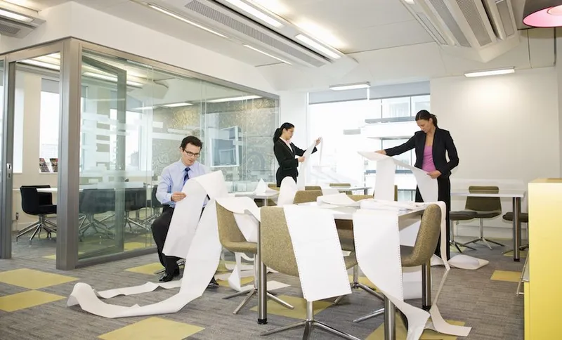 Business colleagues search printouts