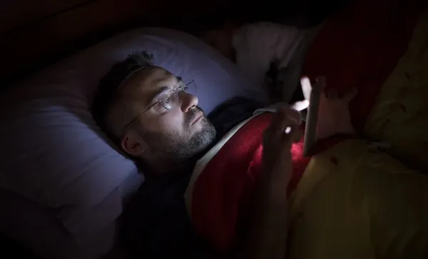 Man using his smart phone in the dark