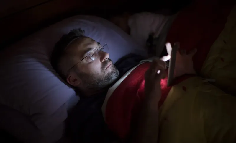 Man using his smart phone in the dark