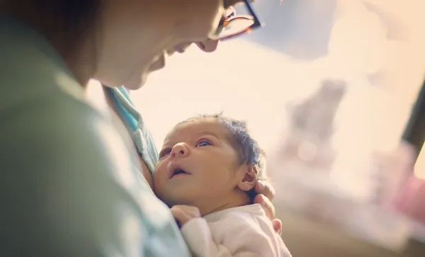 Mom smiling at newborn at hospital