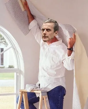 Man wallpapering his home