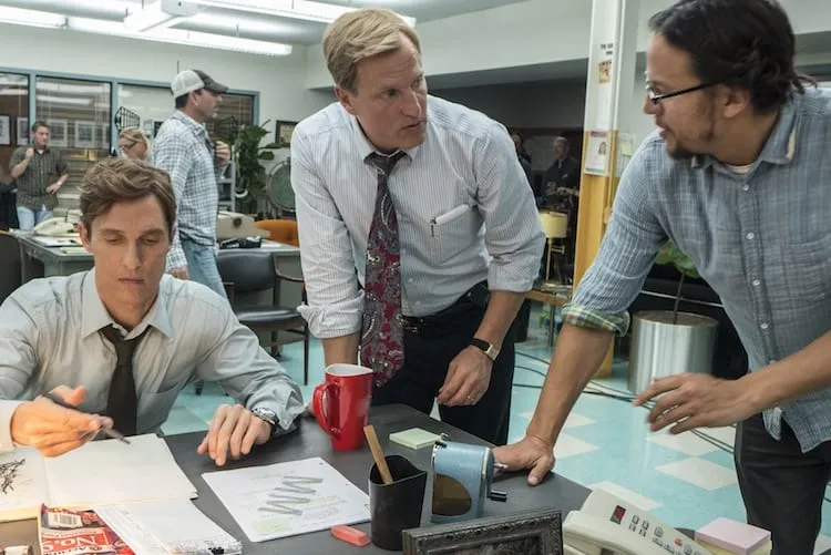 BEHIND THE SCENES: Director Cary Fukunaga with Matthew McConaughey and Woody Harrelson on set. / Photo: Jim Bridges/HBO BEHIND THE SCENES: SCENES 1.20, 1.21, 1.22, 1.23, 1.24, 1.39 & 1.41 / Interior CID HQ-Lobby Press Conference, Mayor Quesada's Office and Squad Room (1995) / Photo: Jim Bridges/HBO HBO's "True Detective" Season 1  Director: Cary Fukunaga Matthew McConaughey: Rustin Cohle Woody Harrelson:  Martin Hart
