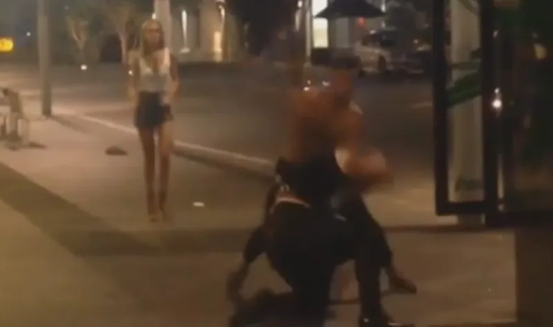 Two men fight on Fort Street, March 20. Seconds later the woman was thrown to the ground.