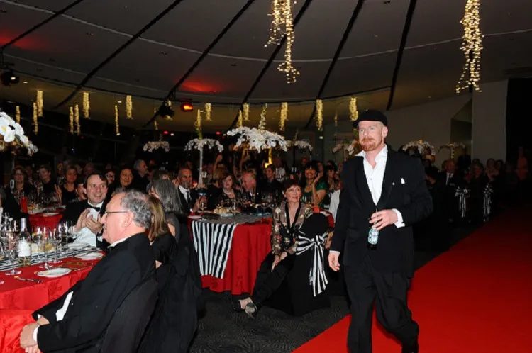 JARROD GILBERT, WINNER OF THE PEOPLE’S CHOICE AWARD IN 2014, MODELS A MATE’S TUX AND A BOTTLE OF PISS
