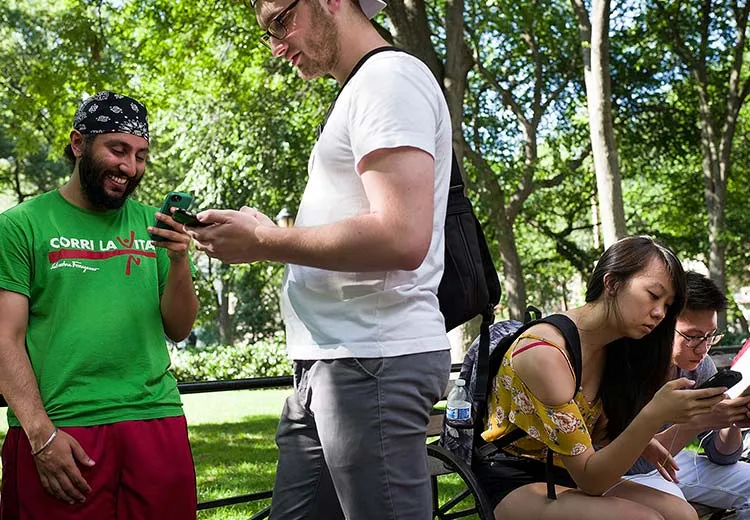 A candid shot of people in a park engaging with the the 21st century's first mass hallucination.