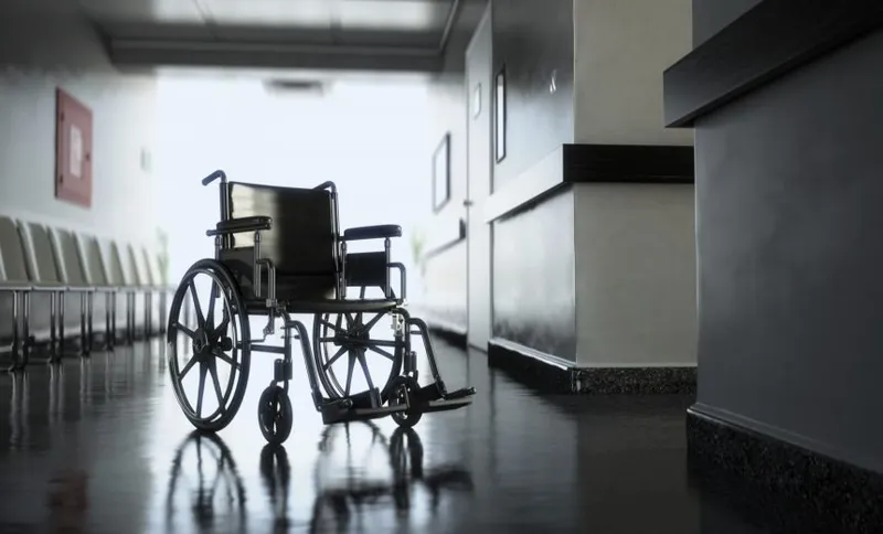 Standard manual wheelchair standing in empty hospital corridor