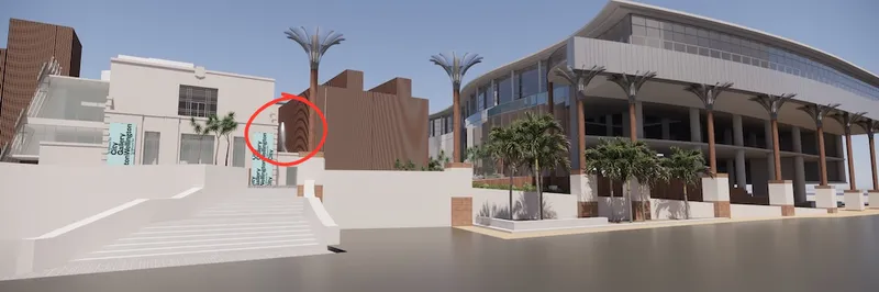 A modern building complex with palm trees, wide steps leading up, and banners reading “COASTAL CONFLUENCE.” A red circle highlights a section of the brown structure next to the white building on the left.