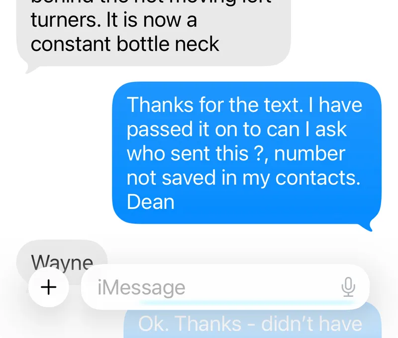 A phone screenshot shows a text conversation about a road incident with a photo of an accident scene blocking a lane. The sender explains the traffic issue. The recipient asks who sent the message as the number isn’t saved.