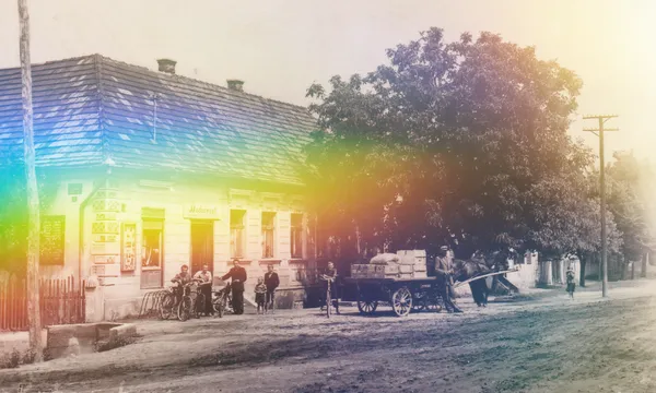 A black and white / sepia image of an old building with tree outside with a rainbow light effect overlaid.