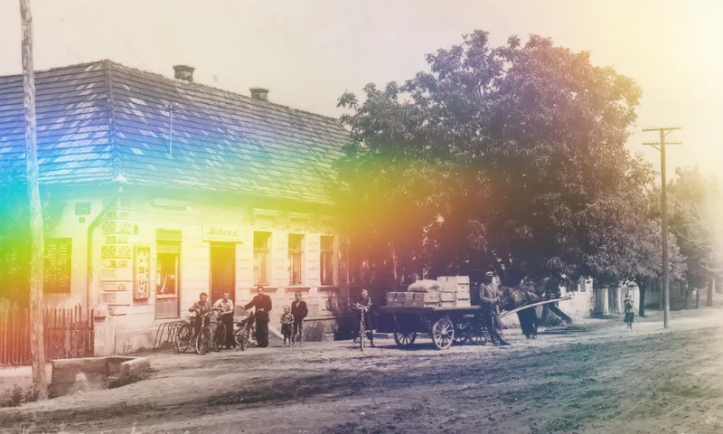 A black and white / sepia image of an old building with tree outside with a rainbow light effect overlaid.