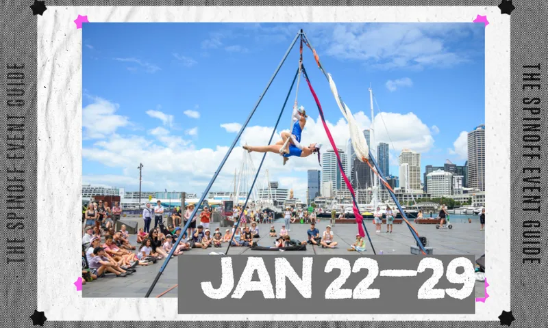 A photograph of circus performers set up outside on a waterfront space with a crowd watching.