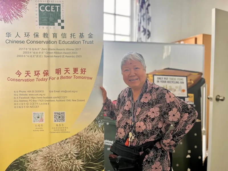 A woman standing next to a poster.