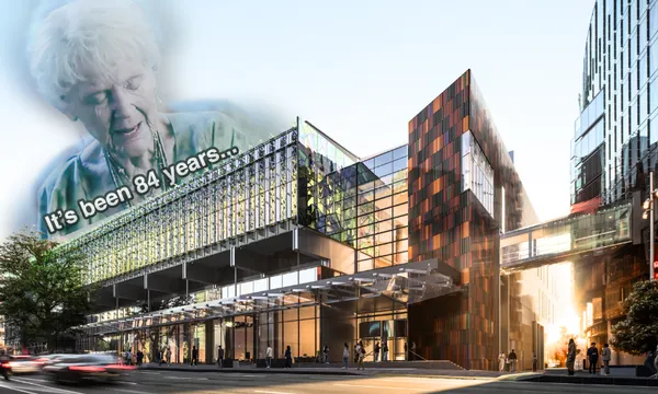 An elderly woman with the caption "It's been 84 years..." is shown in the sky above a modern glass building on a busy city street, referencing a famous meme.