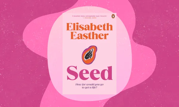 The cover of a novel called Seed which is pink with orange and pink lettering and an illustration of what looks like a pawpaw fruit. Behind the cover are pink blobs.