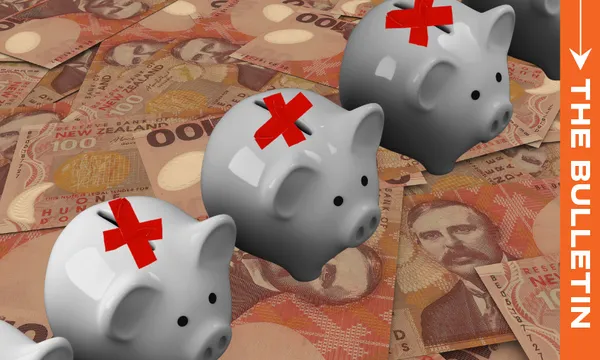 Three gray piggy banks with red tape Xs on them are lined up on top of a pile of New Zealand banknotes. An orange sidebar on the right displays the text “THE BULLETIN.”.