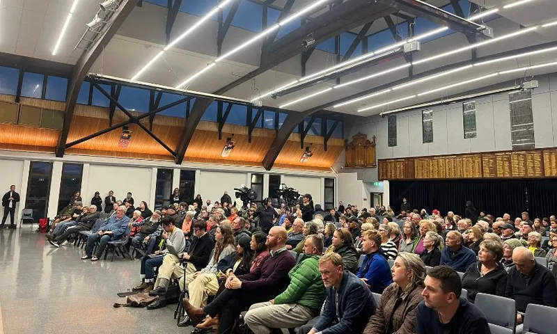 A large venue with multiple rows of seats filled by people.