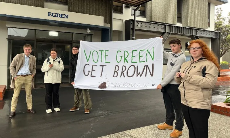 A group of young people hold up a "Vote Green, Get Brown" banner.