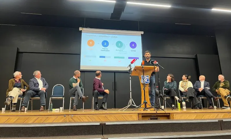 A man at a podium presents a powerpoint.