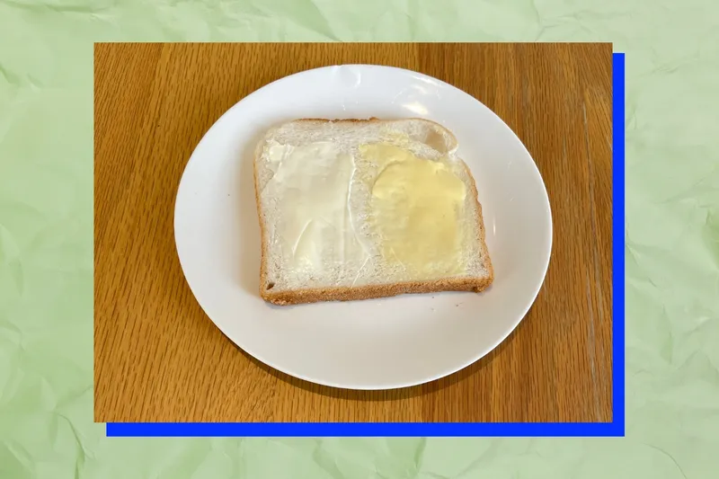 Pale US butter and yellow NZ butter on a slice of white bread.