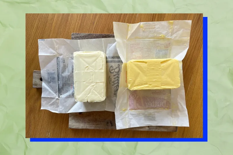 Unwrapped blocks of Burtfield's butter, pale, and Anchor butter, yellow