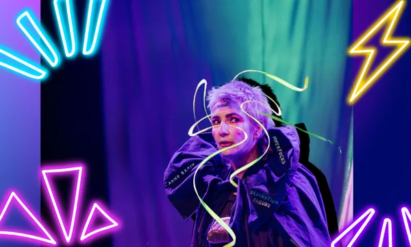 A woman is in costume on a stage with a neon ribbon whizzing around their head. There are neon graphics overlaid.