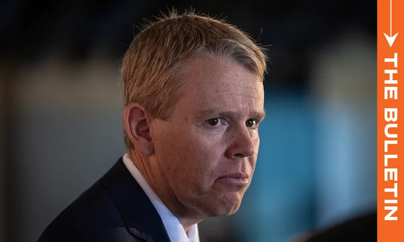 A man in a suit looks serious while facing left; the background is blurred. An orange vertical banner on the right reads "THE BULLETIN" in white text.