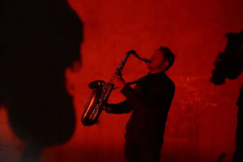 a red toned image of a saxaphonist
