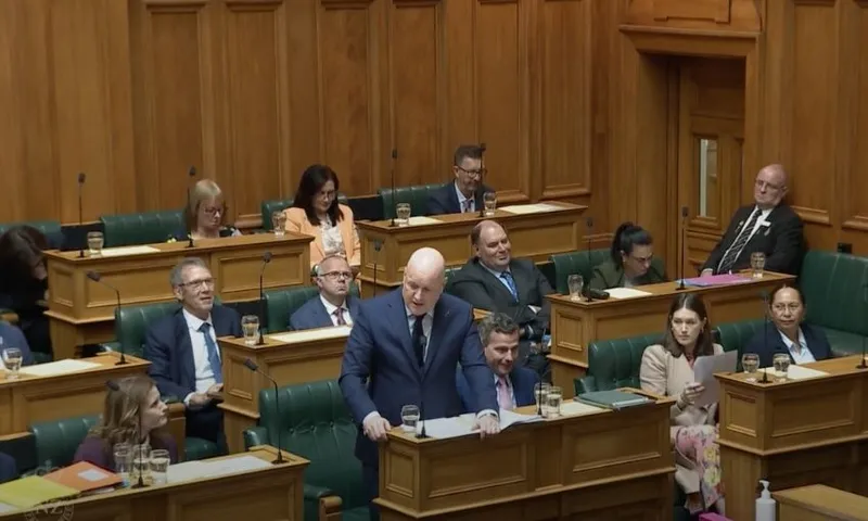 A wide view of the government benches in the debating chamber showing Luxon speaking from his bench.