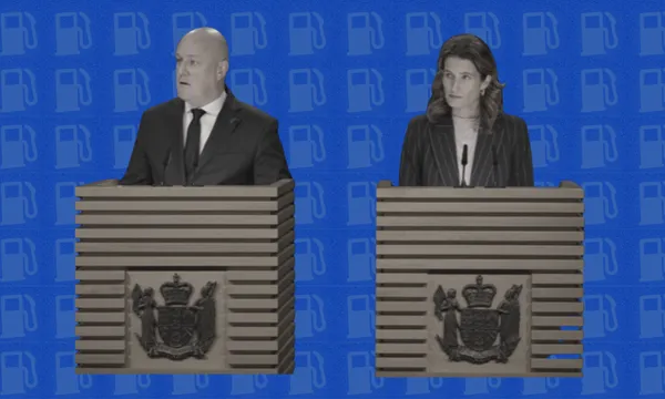 Two people stand at separate wooden podiums with official crests, speaking or listening, against a blue background featuring a repeating gas pump icon pattern.