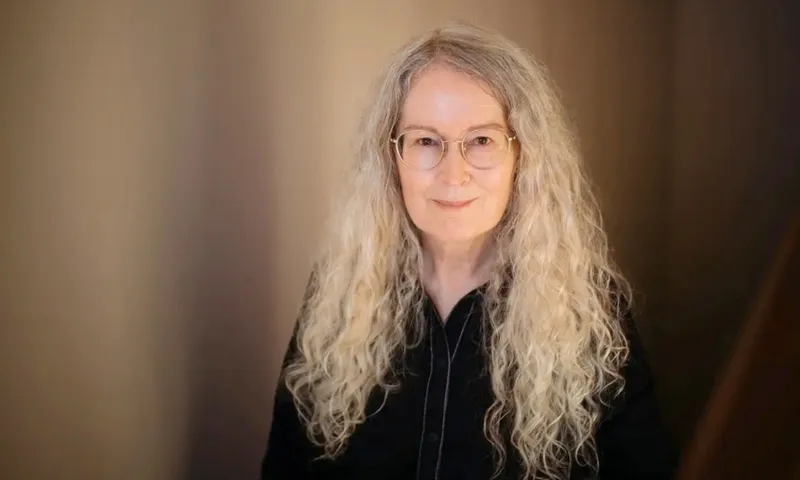 A photo of Elizabeth Knox who has long grey wavy hair and is wearing black.