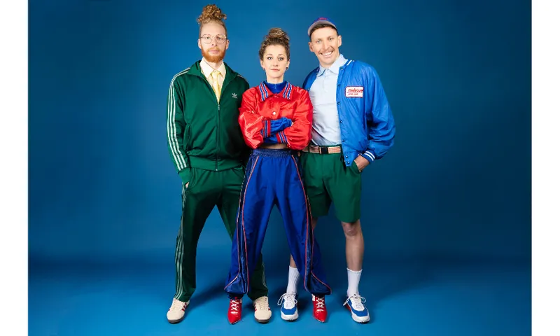 Three people in brightly coloured athleisure wear. Two man flank one woman. They're all looking at the camera and there's a dark blue background.