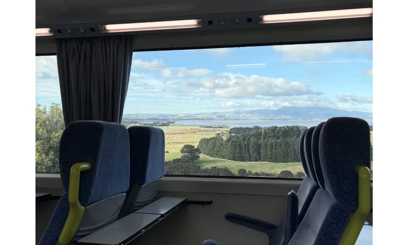 A view out to estuary and hills from inside a train.