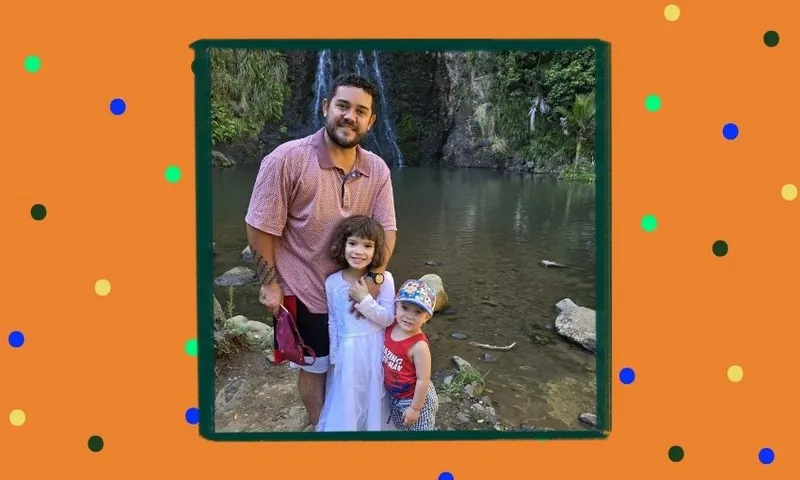 A man and two young children pose by a pond with rocks and greenery in the background. The man stands behind the children, who smile at the camera. The image has an orange border with colorful dots.