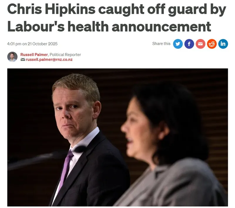 Chris Hipkins looks surprised while sitting next to a woman speaking at a podium during a press conference, as reported by Russell Palmer on Labour’s health announcement.