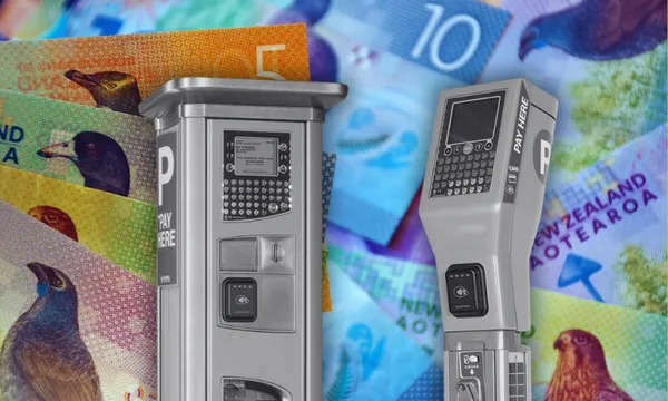 two grey parking machines overlaid on a pile of new zealand bank notes